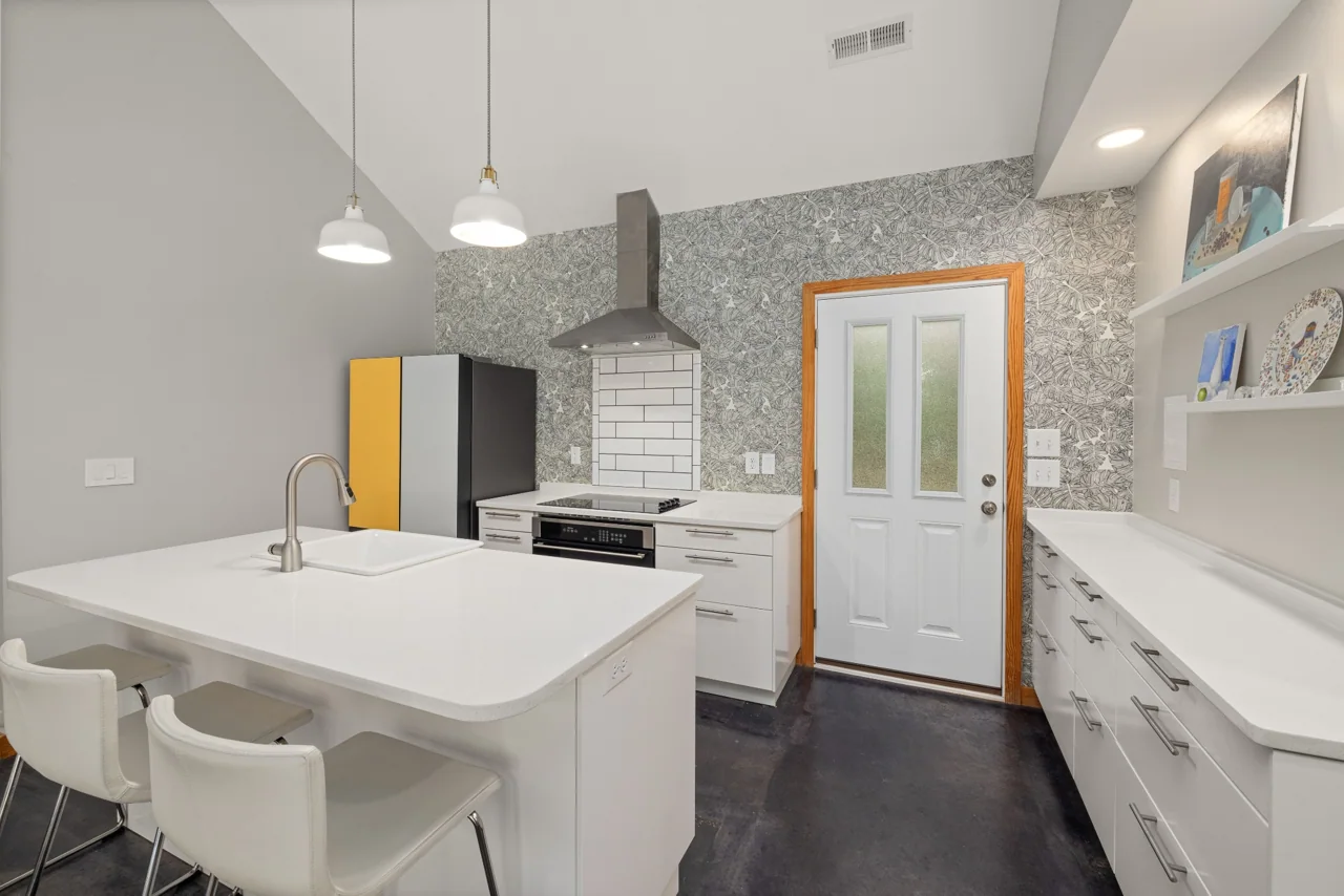 Bright kitchen with a white island, pendant lighting and light cabinetry